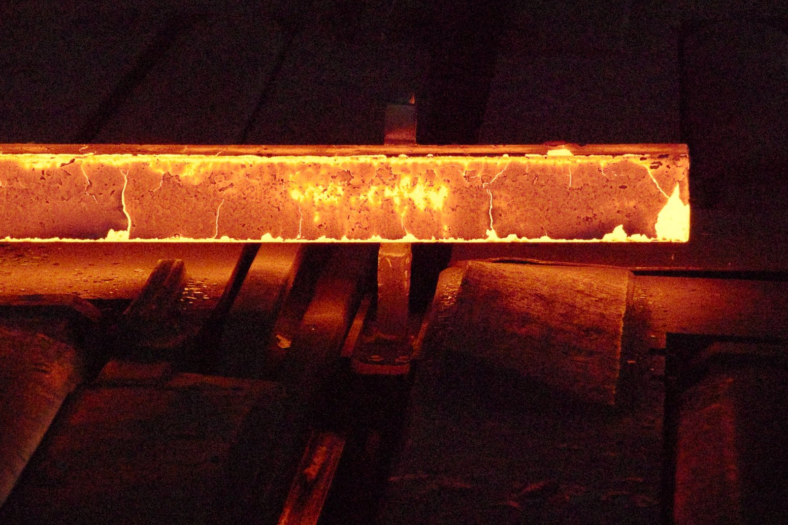 Hot steel passing through industrial rolling mill rollers